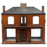Large antique scratch built wooden doll's house with various glass panels and brass carrying