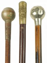 Three military interest swagger sticks with regimental pommels, the largest 71cm in length : For