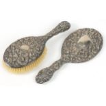 Victorian silver backed dressing table hand brush and similar mirror, each profusely embossed with