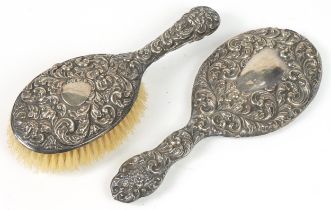 Victorian silver backed dressing table hand brush and similar mirror, each profusely embossed with