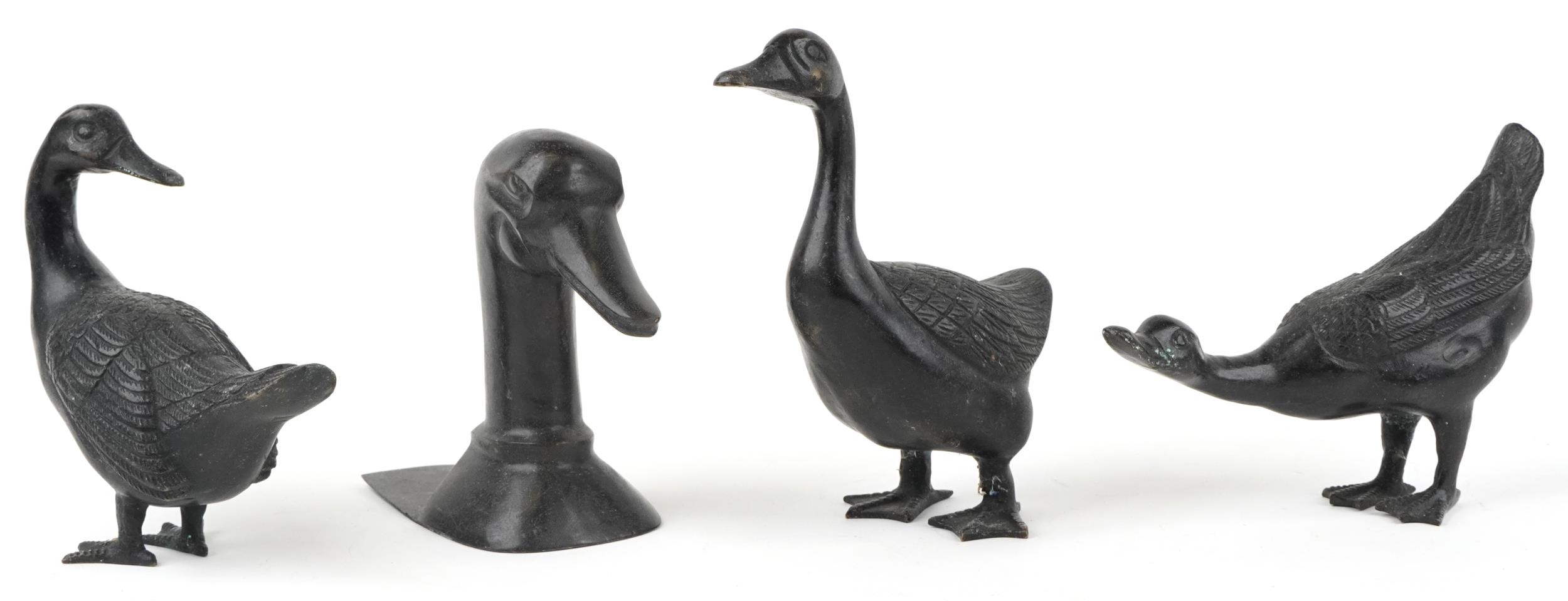 Three patinated bronze ducks and a patinated bronze book end in the form of a duck's head, the