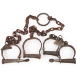 Two pairs of 19th century cast iron handcuffs with tags engraved Abbeville 1844 Daddy Toby no 88 and