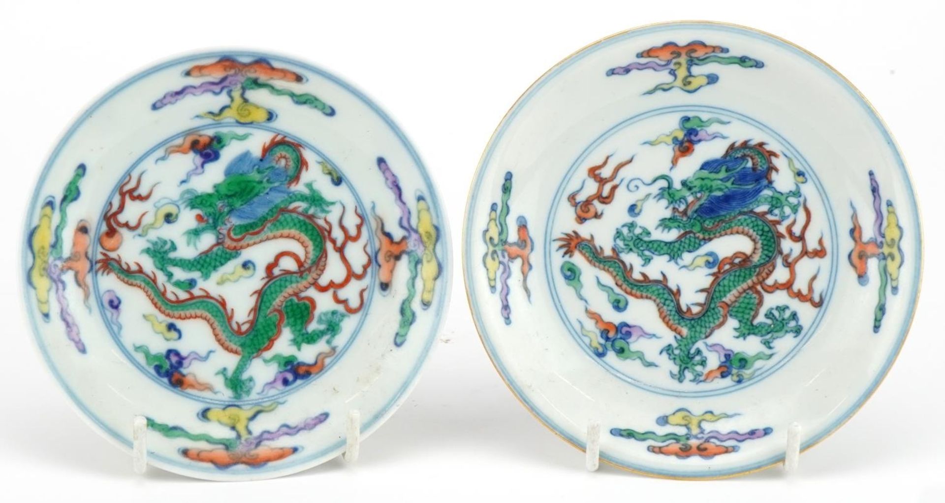 Two Chinse doucai porcelain dishes, each hand painted with a dragon chasing the flaming pearl