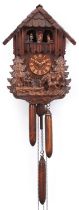 German Black Forest wall clock carved with a farrier beside horse and foal, 36cm high