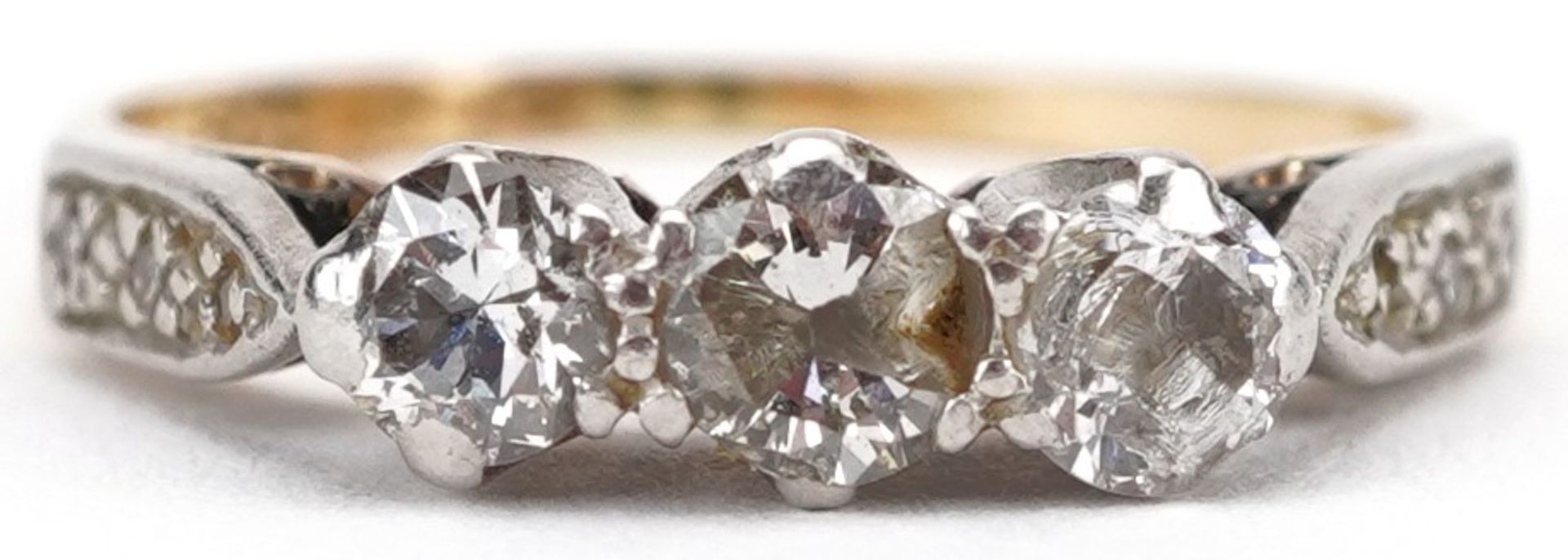 18ct gold and platinum diamond three stone ring with diamond set shoulders, the central diamond