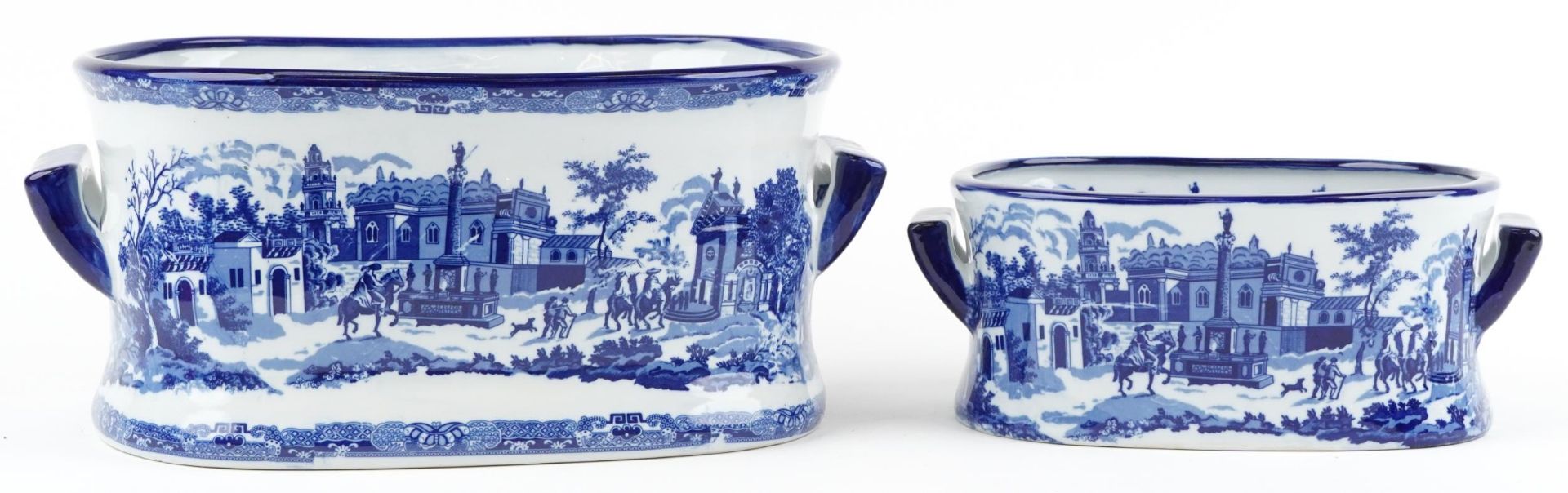 Two blue and white porcelain planters with twin handles, each decorated with cavaliers on horseback,
