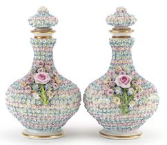 Pair of 19th century continental floral encrusted porcelain scent bottles with stoppers, each 20cm