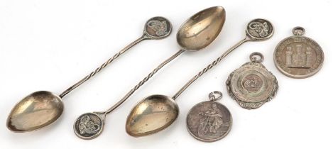 Silver motorcycling interest objects comprising three sports jewels and three teaspoons, the