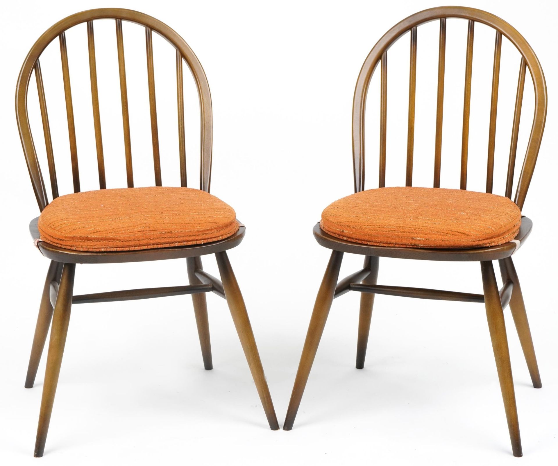 Two Ercol stick back dining chairs with cushioned seats, each 83cm high