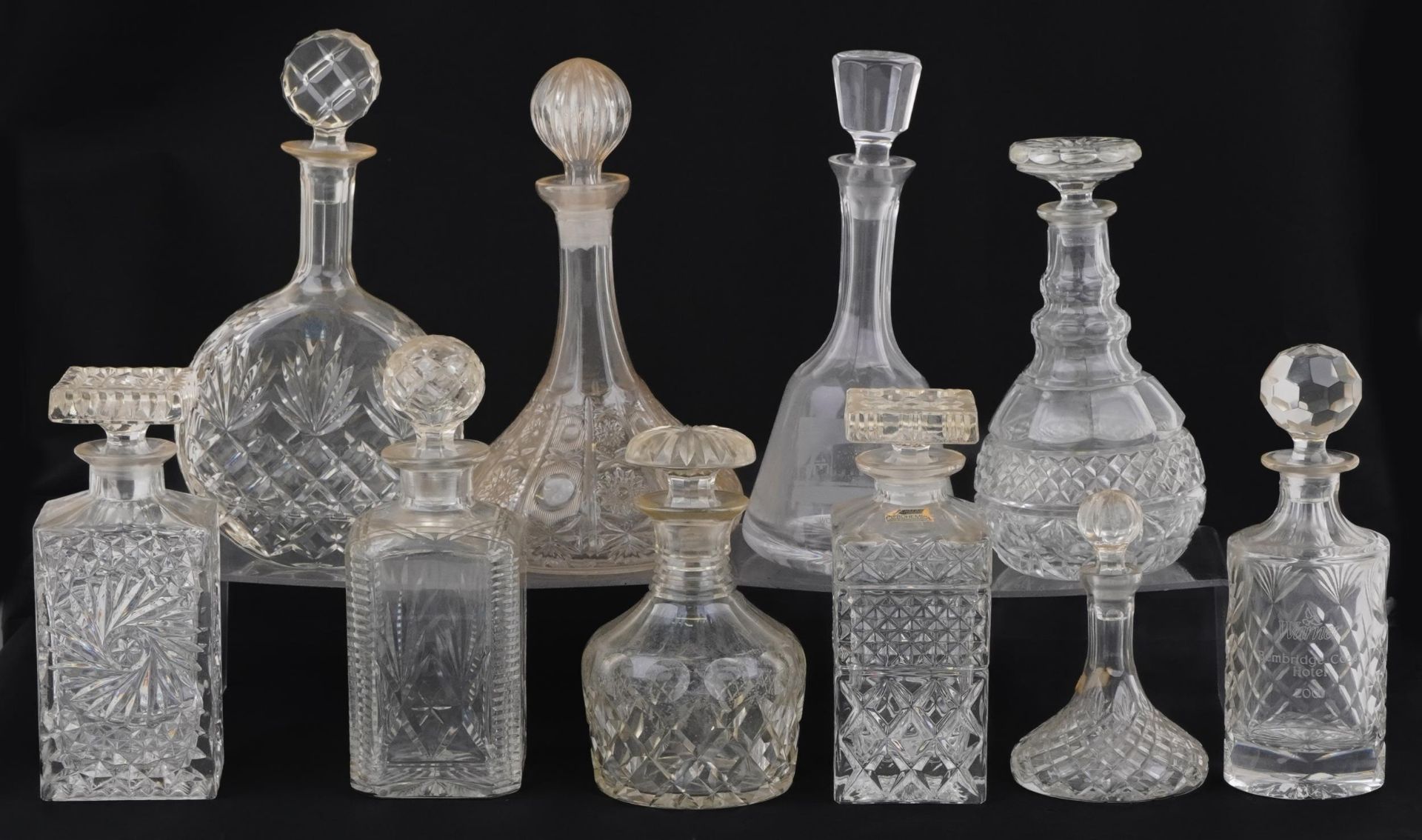 Nine glass decanters including a ship and Bohemian examples, the largest 30cm high