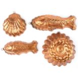 Four vintage coppered jelly moulds including two in the form of fish, the largest 42cm in length