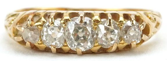 18ct gold graduated diamond five stone ring with engraved scrolled shoulders, the largest diamond