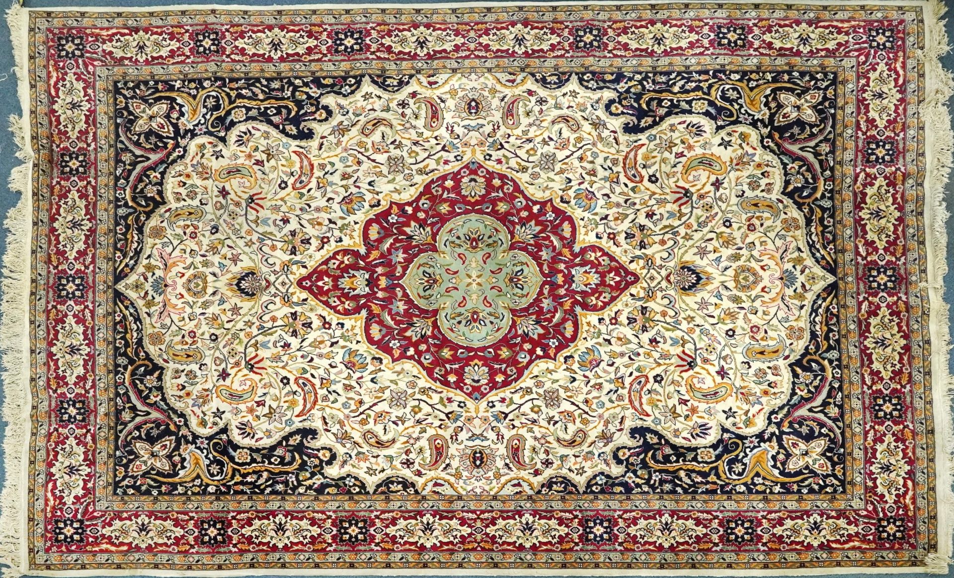 Rectangular Persian cream and red ground rug having an all over repeat floral design, 370cm x 270cm