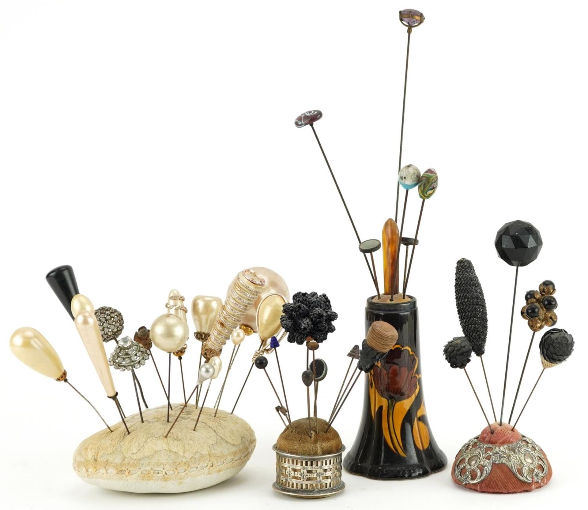 Collection of early 20th century and later hatpins arranged in four hatpin stands including two