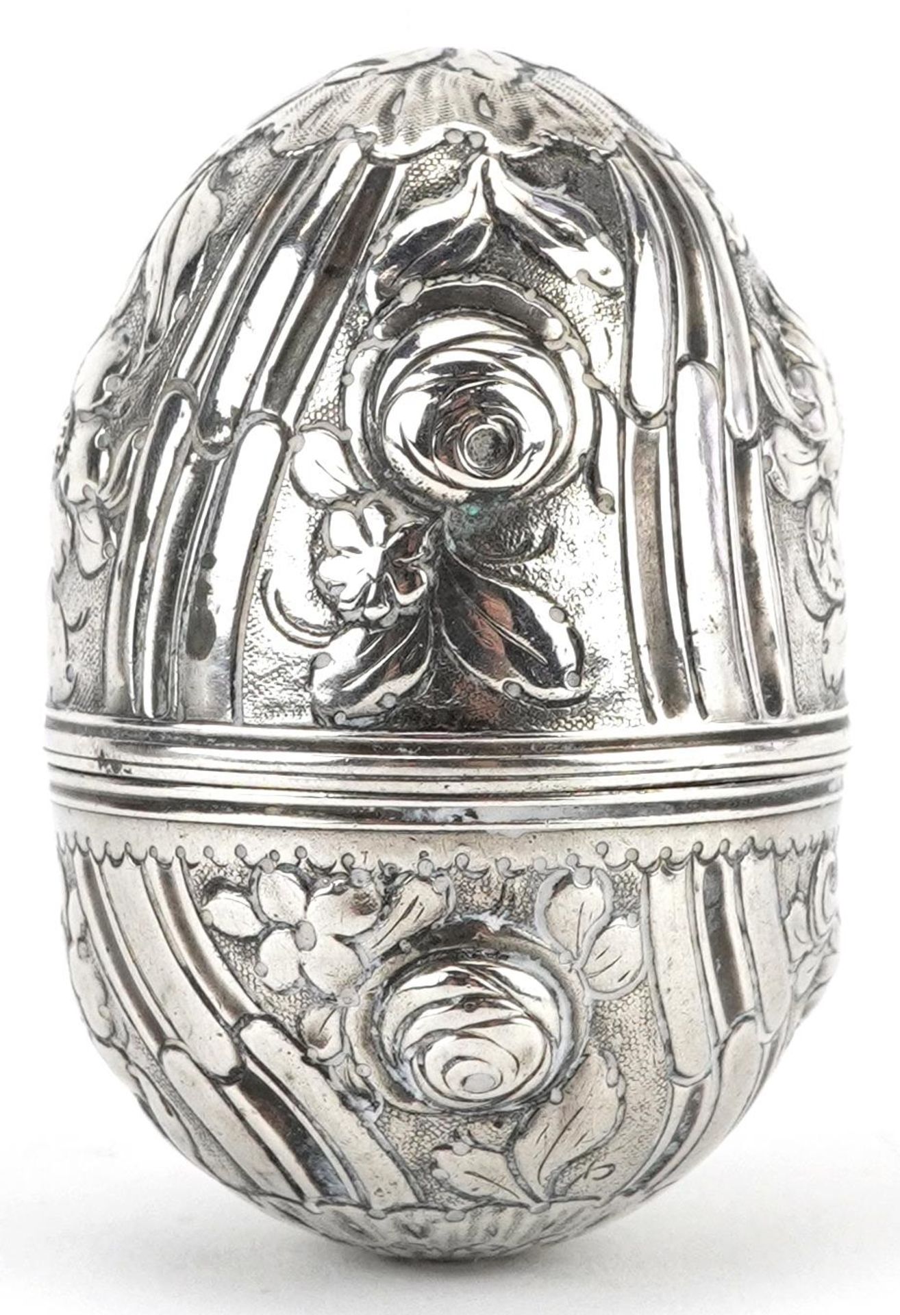 Unmarked silver trinket box in the form of an egg embossed with flowers and foliage, 5cm high, 15.4g