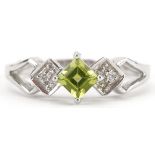 9ct white gold peridot and diamond three stone ring with split shoulders, size N, 3.0g