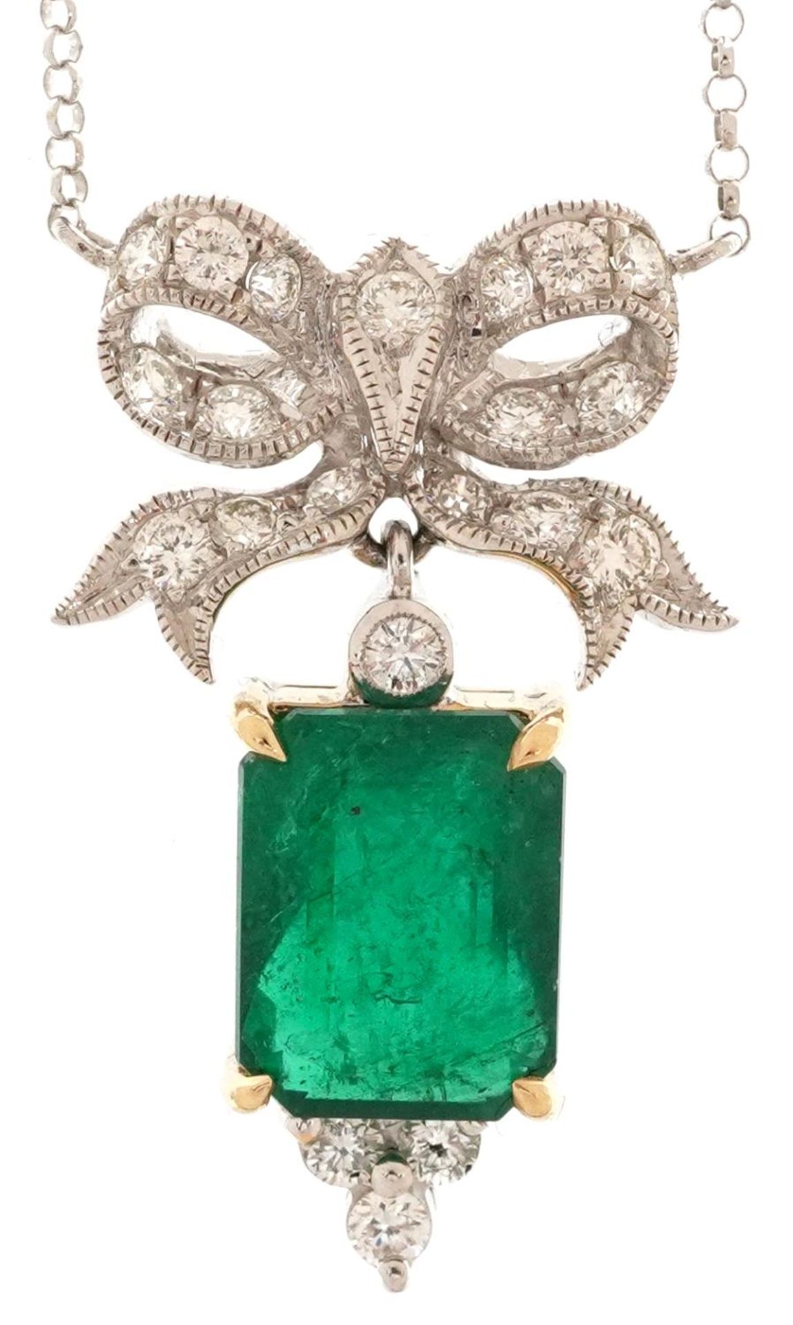 18ct white and yellow gold diamond and emerald pendant in the form of a bow on an 18ct white gold