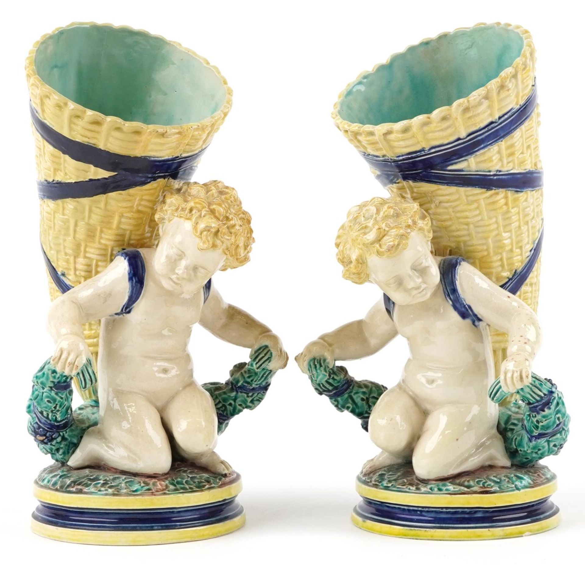 Pair of 19th century European Maiolica vases in the form of Putti carrying cornucopia, each with