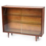 Mid century teak bookcase fitted with two sliding glass doors enclosing two adjustable glass