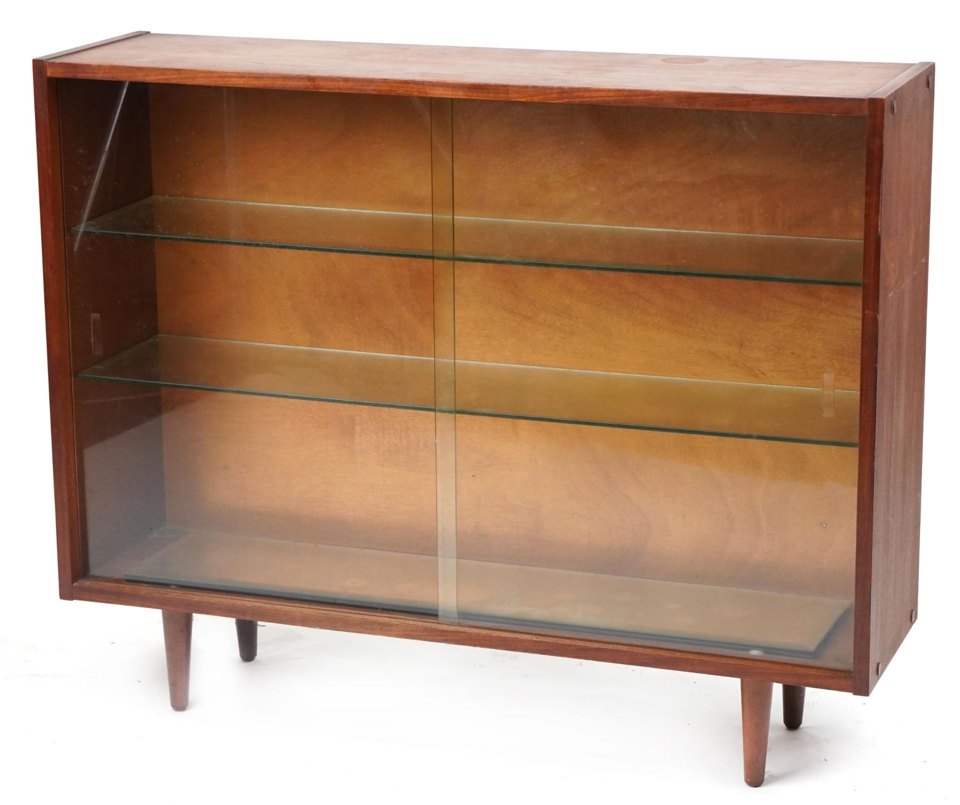 Mid century teak bookcase fitted with two sliding glass doors enclosing two adjustable glass