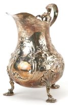 William Robert Smily, Victorian silver three footed cream jug embossed with flowers and foliage,