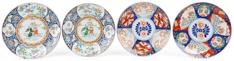 Four Japanese porcelain chargers including a pair hand painted with figures and panels of flowers,