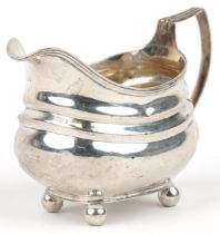 George III silver cream jug with four ball feet, indistinct maker's mark London 1819, 13cm in