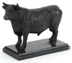 Patinated bronze study of a bull raised on a black marble base, 26cm in length