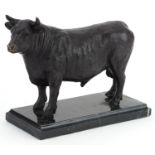 Patinated bronze study of a bull raised on a black marble base, 26cm in length