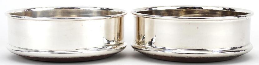 Pair of silver plated and oak circular wine coasters, 12.5cm in diameter