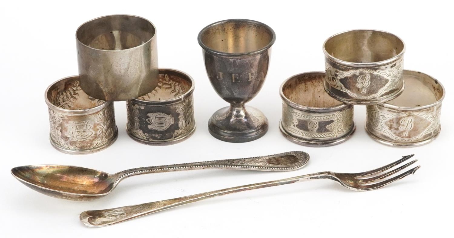 Victorian and later silver comprising six napkin rings, eggcup, pickle fork and tablespoon, the