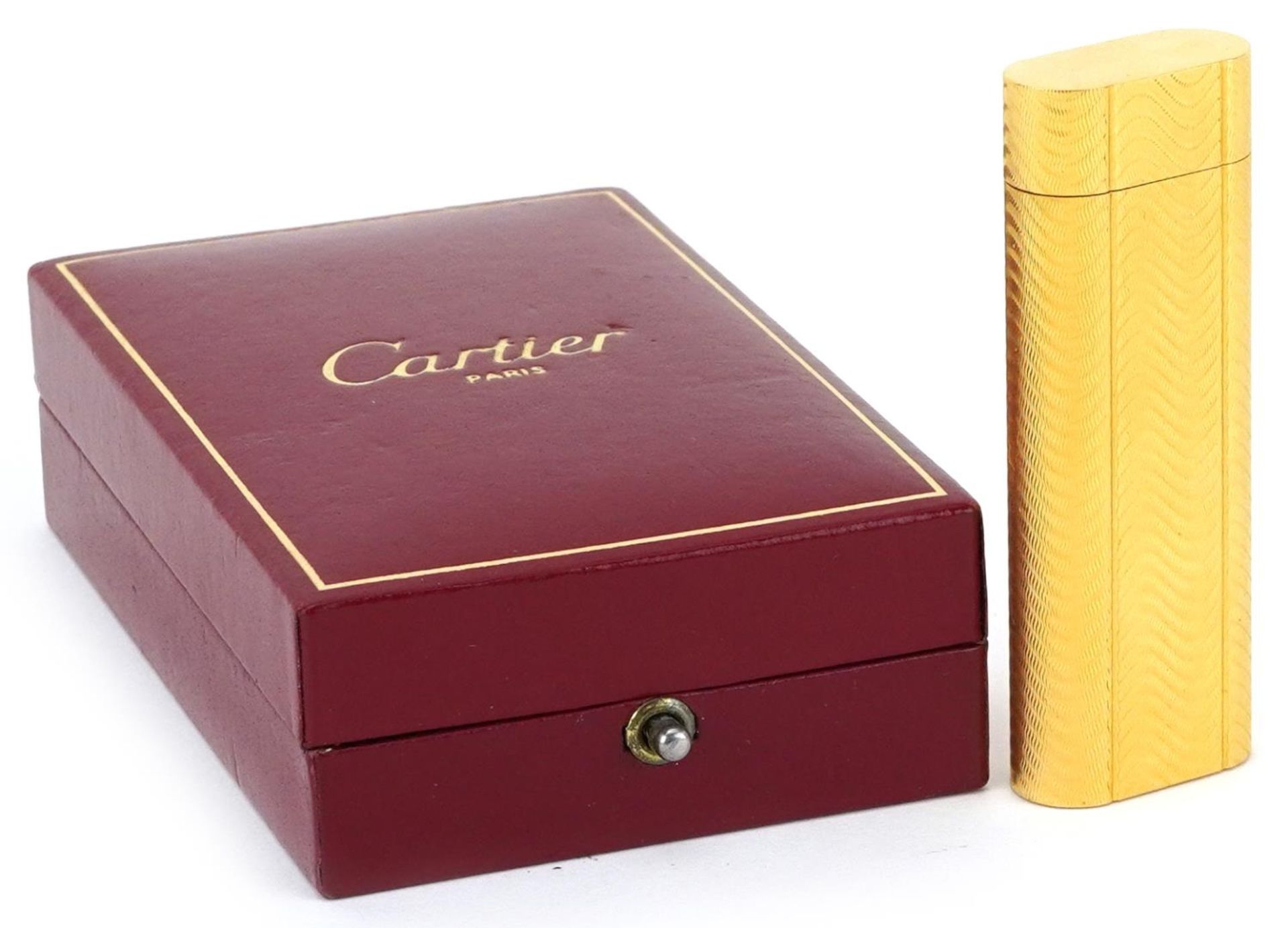 Cartier, gold plated French engine turned pocket lighter with box numbered D24339, 7cm high