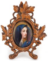 German Black Forest wooden frame carved with leaves and berries housing an oval porcelain plaque