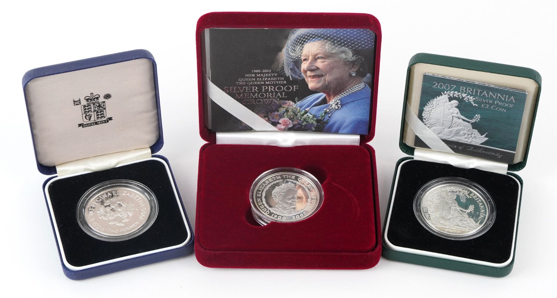 Three silver proof coins with cases including 2007 Britannia two pound and Memorial crown