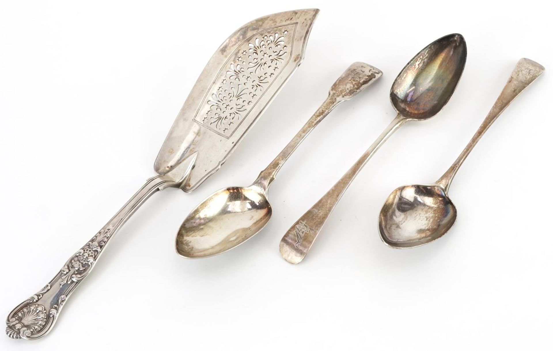 George IV and later silver comprising three Georgian tablespoons and a Victorian fish slice by