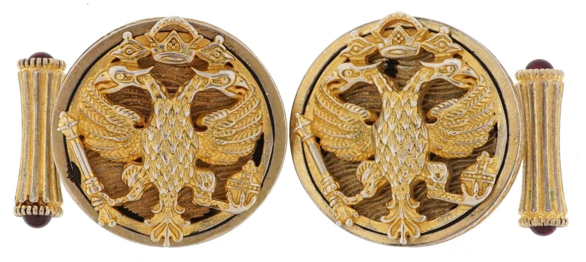 Pair of silver gilt double eagle head design cufflinks set with cabochon rubies, each 2.6cm in