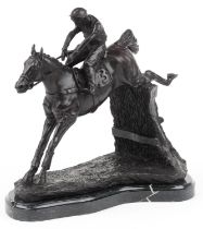 Patinated bronze statue of a jockey on horseback raised on a shaped black marble base, 35cm in