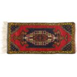 Rectangular Persian red and blue ground rug having an allover repeat floral design, 120cm x 53.5cm