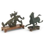 Two Chinese archaic style verdigris cast metal animals including a dragon, each raised on hardwood