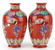 Pair of Japanese iron red ground porcelain vases hand painted with a continuous band of Geishas