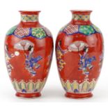 Pair of Japanese iron red ground porcelain vases hand painted with a continuous band of Geishas