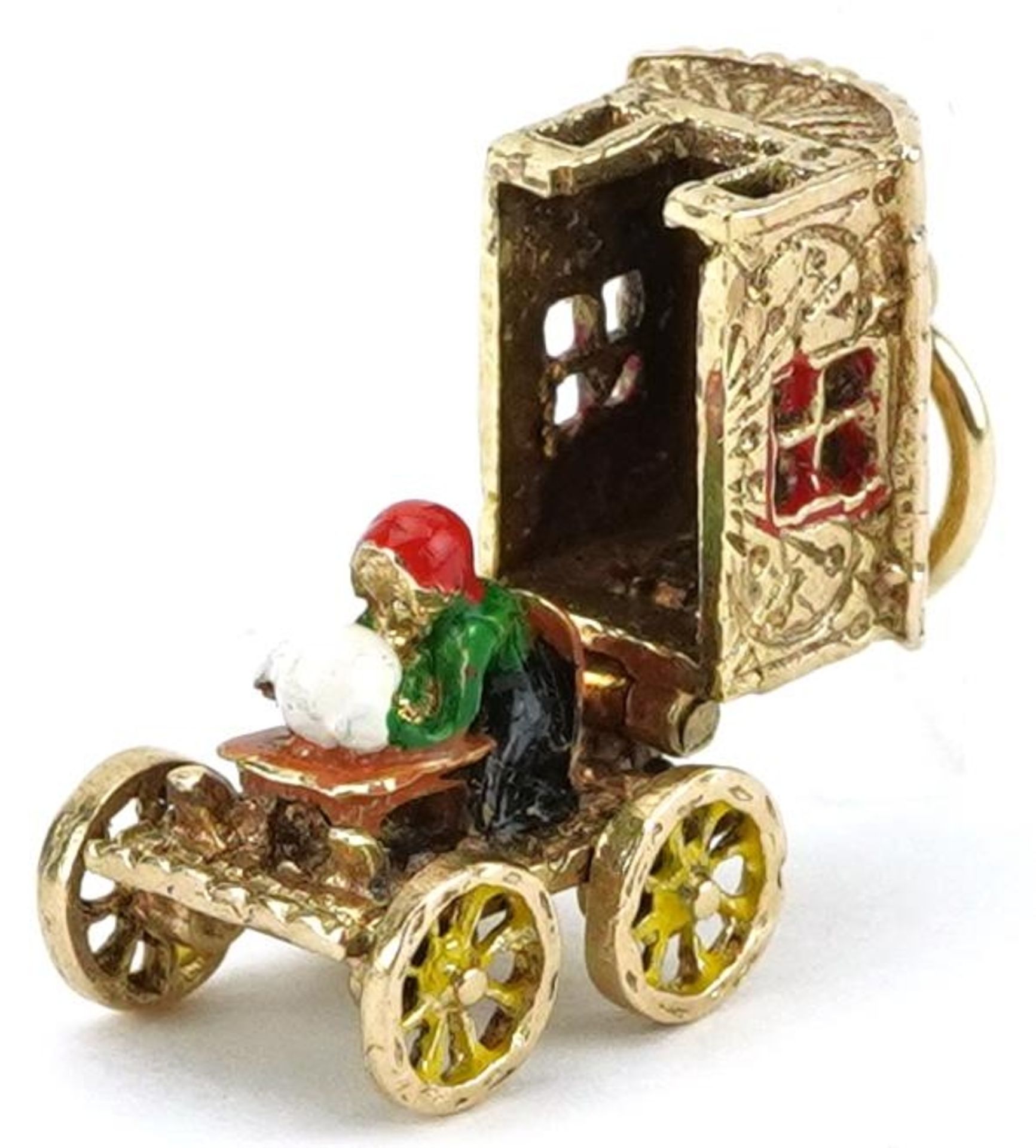 9ct gold and enamel charm in the form of a Gypsy wagon with rotating wheels opening to reveal a