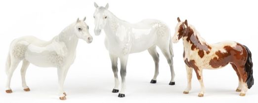 Three Beswick collectable horses comprising pinto skewbald pony, two dapple grey examples, one