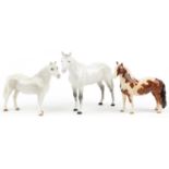 Three Beswick collectable horses comprising pinto skewbald pony, two dapple grey examples, one