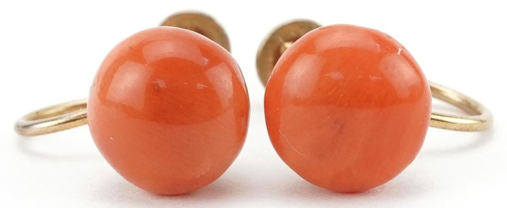 Pair of yellow metal coral earrings with screw backs, each 9mm in diameter, total 2.6g