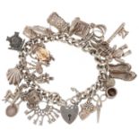 Silver charm bracelet with love heart padlock and a collection of mostly silver charms including