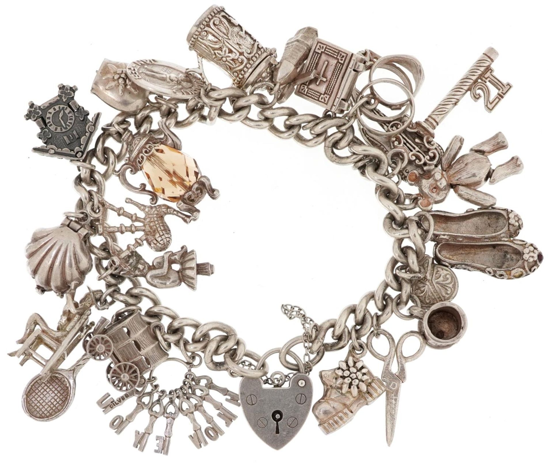 Silver charm bracelet with love heart padlock and a collection of mostly silver charms including