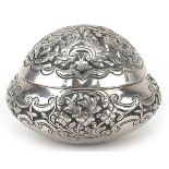 Tibetan unmarked silver bun shaped box with hinged lid profusely embossed with flowers and