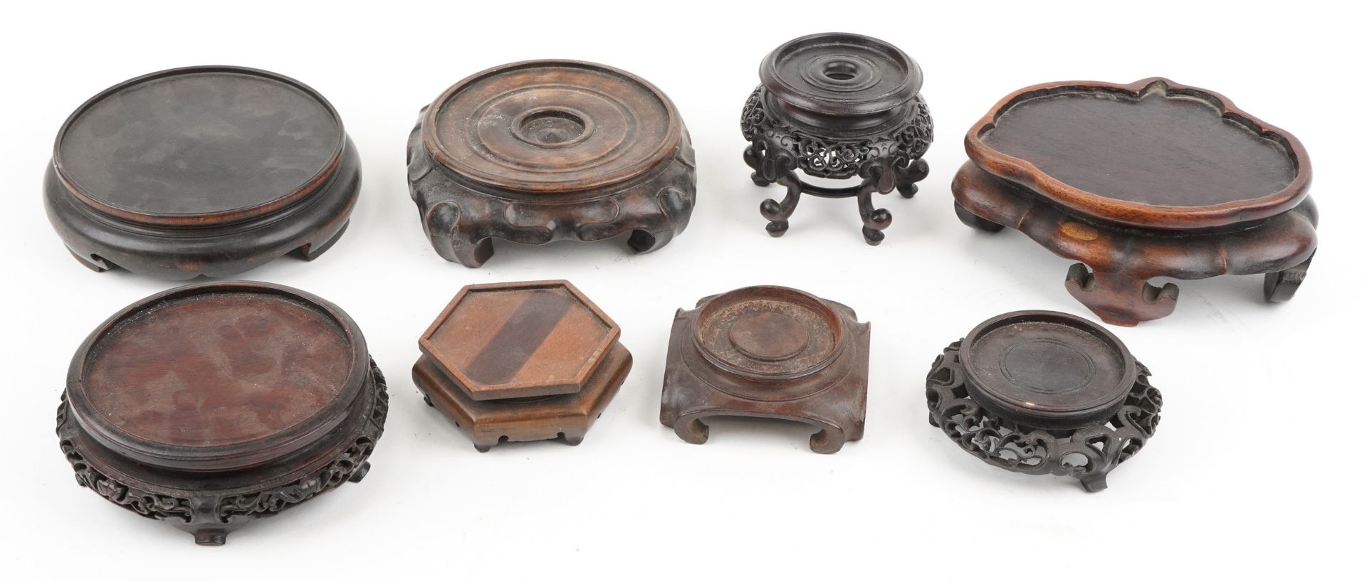 Eight antique Chinese carved hardwood stands, some possibly Hongmu, the largest 16.5cm wide