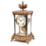 19th century ormolu four glass mantle clock striking on a gong with urn finial and circular